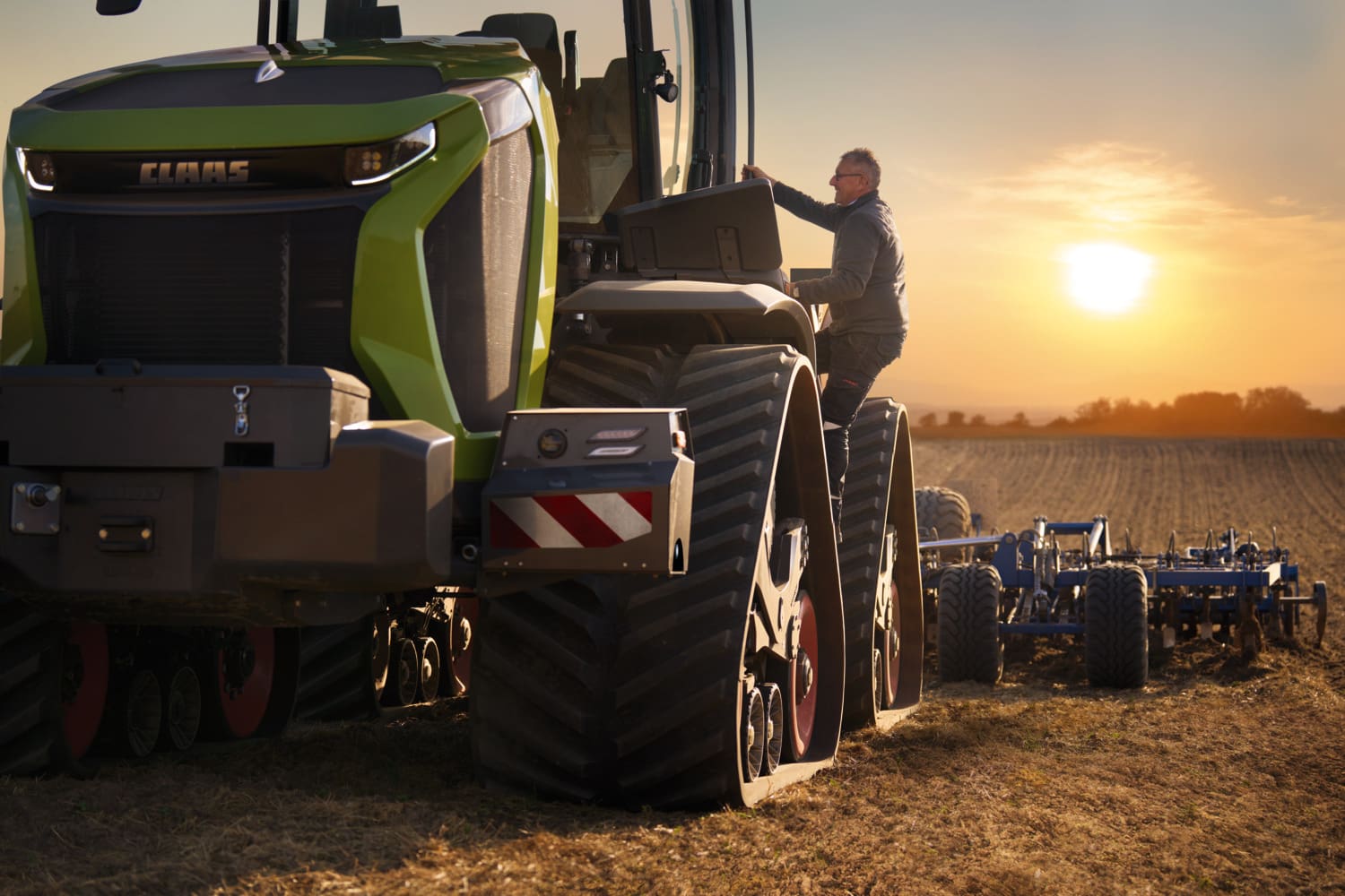 man climbing up steps into Tractor Cab