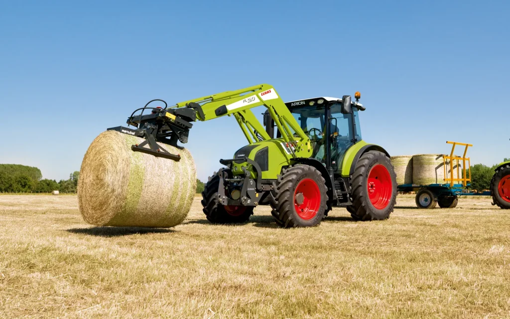 claas arion 410 with front loader moving bale