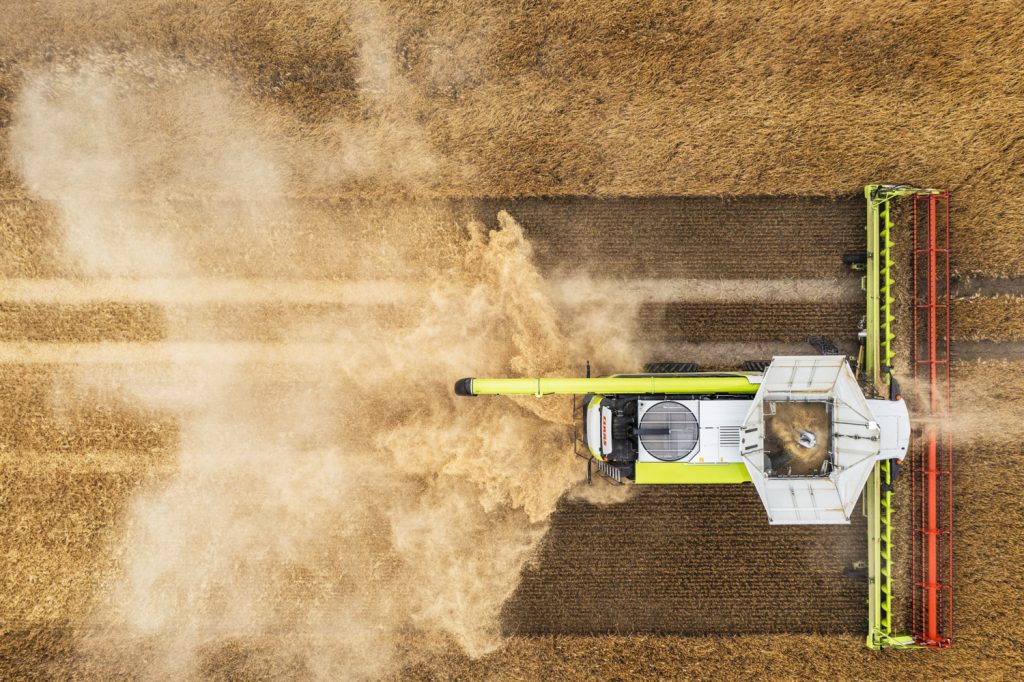 birds eye view of LEXION harvesting field of crops