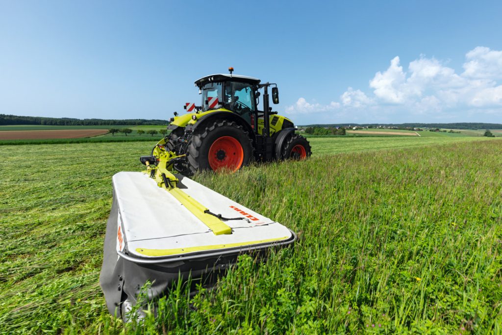 side on image of a claas tactor and claas disco rear mower