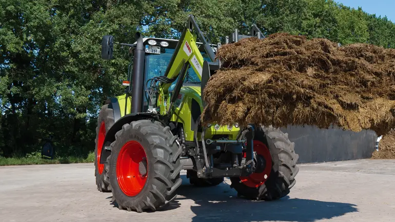 Arion 400 with front loader shifting silage