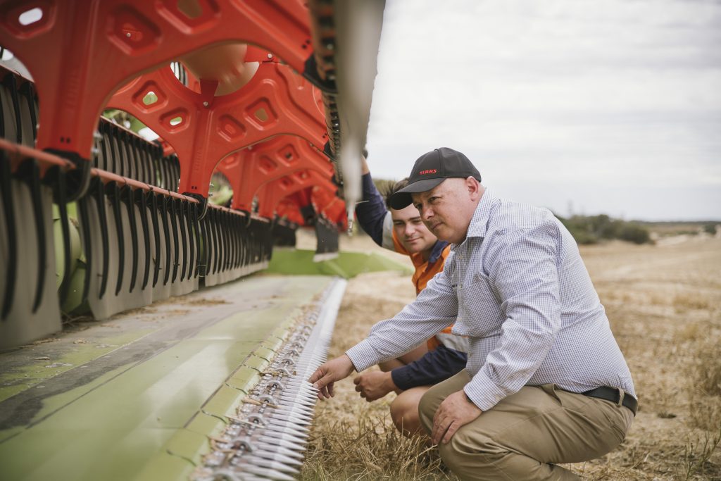 Dillon Parkhouse and CLAAS Harvest Centre staff member inspects LEXION front cutterbar